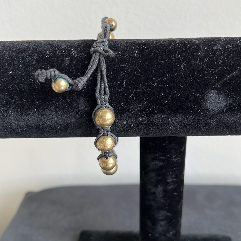 Gold tone bracelet on black cord - Picture 2 of 2
